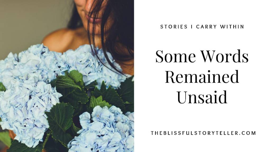 A girl is holding a flower bouquet in her hands. The flowers are bluish white.